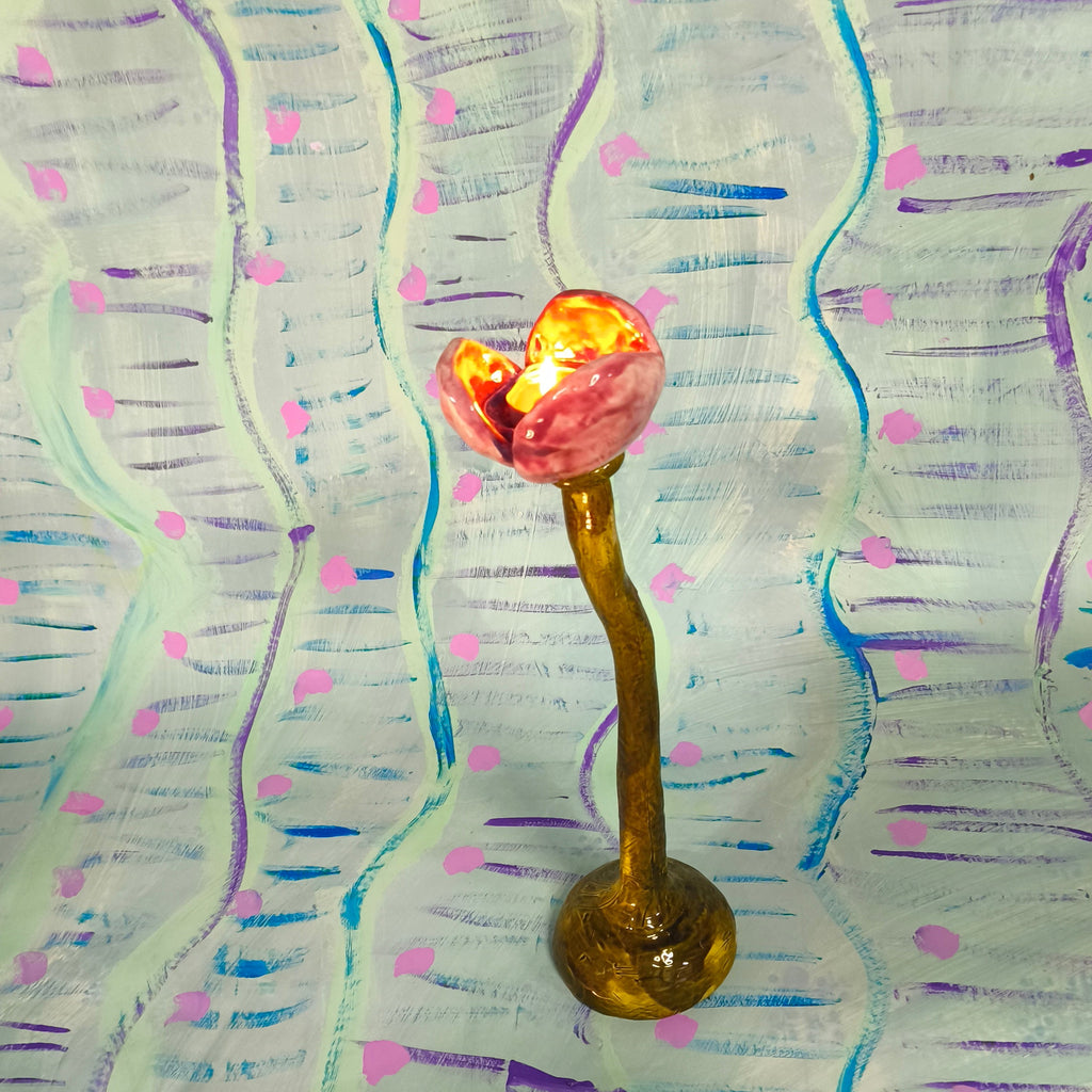 Decorative object with a pink and gold design on a wavy, multicolored background